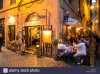 outdoor-restaurants-in-a-cobbled-street-in-rome-at-night-E48RCA.jpg